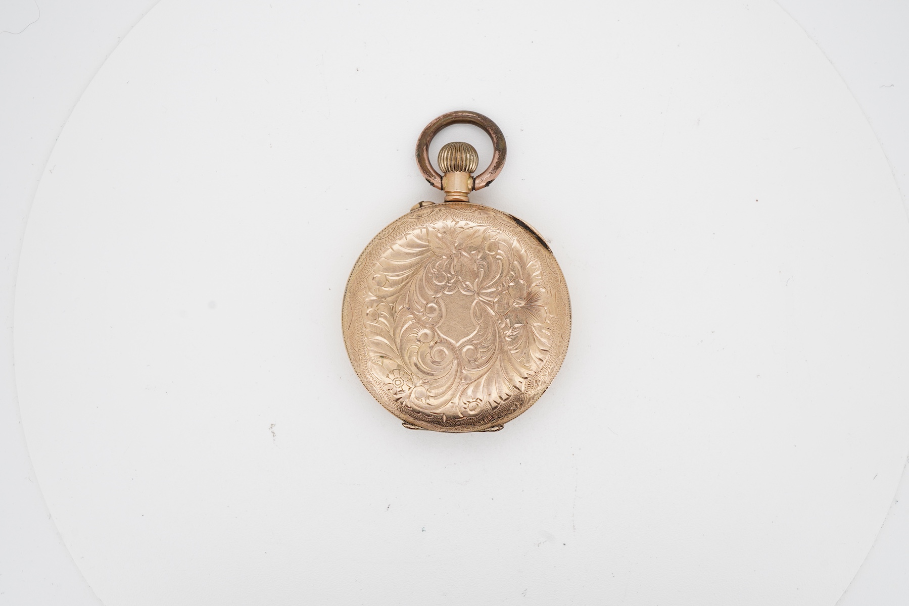 A lady's late 19th century Swiss engraved 14k keyless open faced fob watch, lacking glass, case diameter 32mm, with gilt metal inner cuvette, gross weight 27.6 grams.